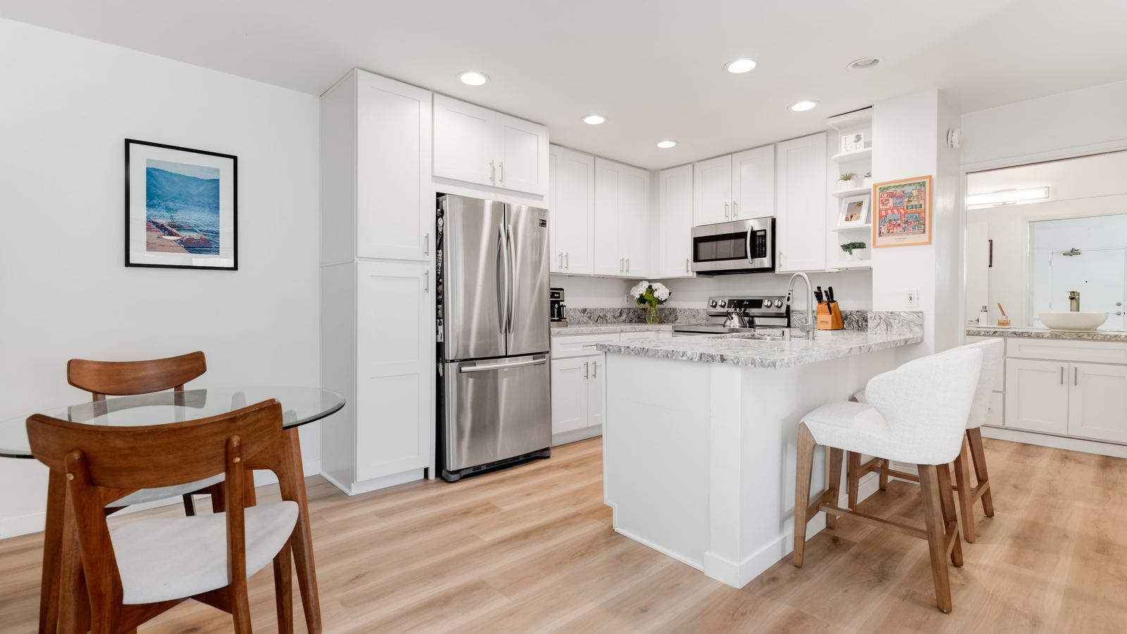 White kitchen with an island and stainless steel appliances